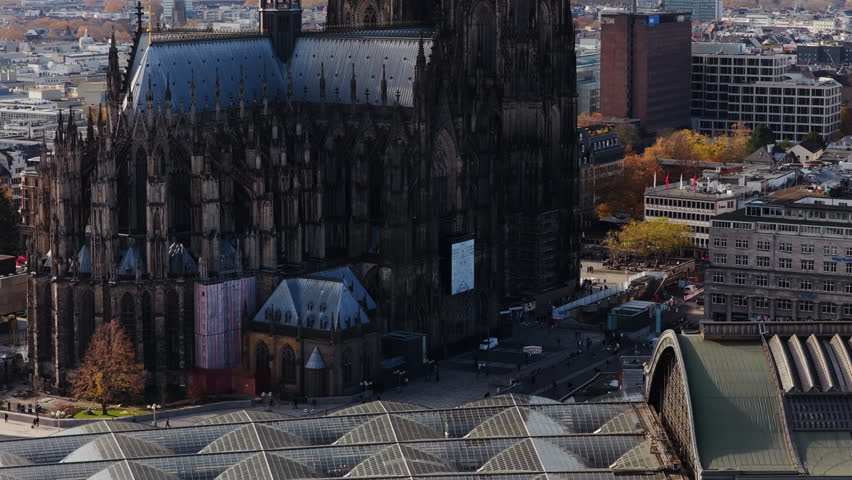 Majestic Cologne Cathedral with its twin spires rising above cityscape. Aerial view of gothic architecture and surrounding buildings