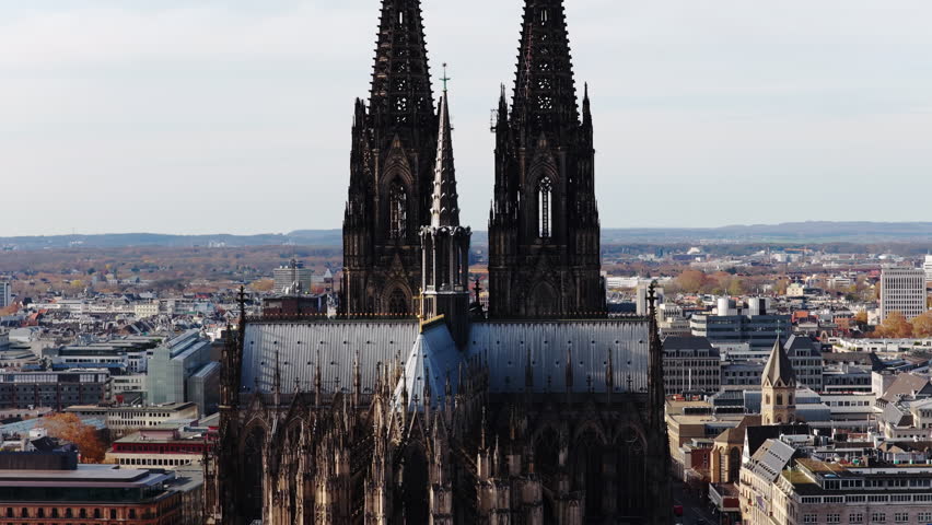 Famous gothic Cologne Cathedral stands tall against cityscape. Aerial view showcasing Germany historic landmark and twin spires