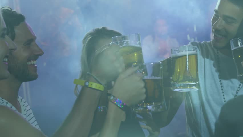 Five friends raising beer mugs, clinking, drinking and toasting under blue fog lights for marketing. Steins, nightlife, bar, camaraderie, toast, ambience, laughter