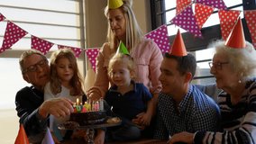 Senior man presenting birthday cake with candles while family guiding toddler, confetti falling. Multigenerational, kinship, celebration, dessert, hats, bunting, glitter - Powered by Shutterstock - Get 15% off with code: PIKWIZARD15