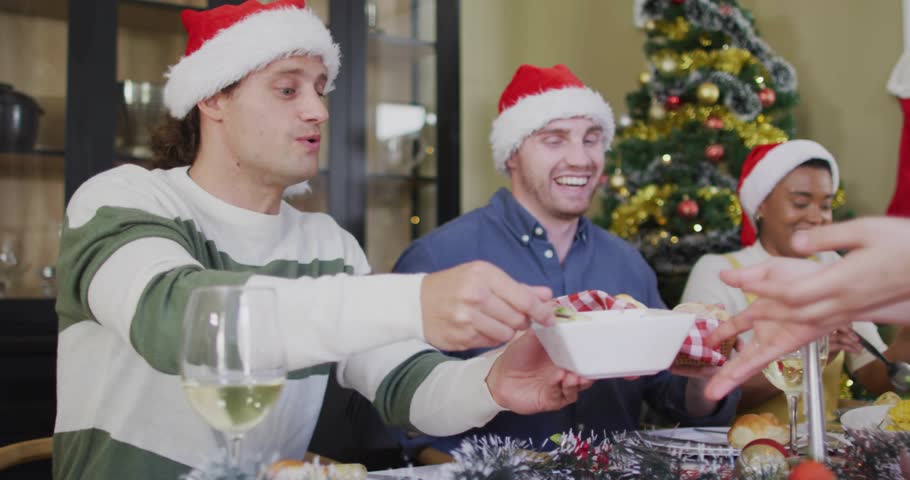 Guests passing dishes as server bringing plates sharing Xmas meal while overlay flickering on table. Festive, family, friends, christmas, cozy, gathering, decorations