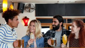 Man speaking and starting toast at pub, friends clinking mugs while red hearts overlaying group. Bar, convivial, casual, cocktails, beer, smartphones, laughter - Powered by Shutterstock - Get 15% off with code: PIKWIZARD15