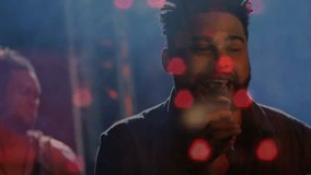 Lead vocalist starting song in music set, projecting vocals moving crowd, bokeh pulsing over singer. Stage, band, guitarist, microphone, haze, venue, moody - Powered by Shutterstock - Get 15% off with code: PIKWIZARD15