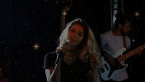 Lead vocalist performing on dim stage, band playing and music building sparkles accenting hair whip. Singer, live, concert, performance, venue, guitar, bass - Powered by Shutterstock - Get 15% off with code: PIKWIZARD15