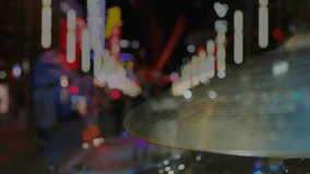 Male drummer entering frame, striking cymbal with stick, making music, neon streaks, drawing crowd. Percussion, urban, nightlife, streetscape, motion, blur, reflections - Powered by Shutterstock - Get 15% off with code: PIKWIZARD15