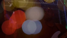 Male bassist performing on music stage, colored bokeh shifting to reveal bass and face. Silhouette, musician, live, concert, lighting, truss, neon - Powered by Shutterstock - Get 15% off with code: PIKWIZARD15