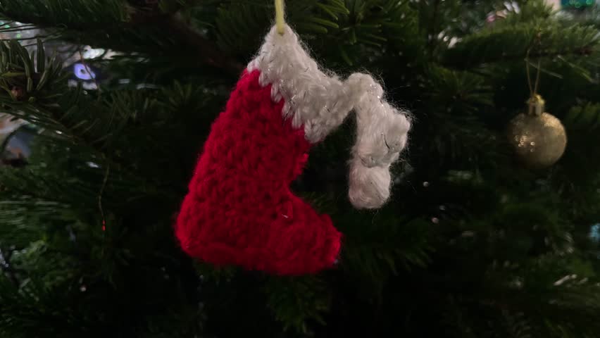 A beautiful red sock on a Christmas tree.
