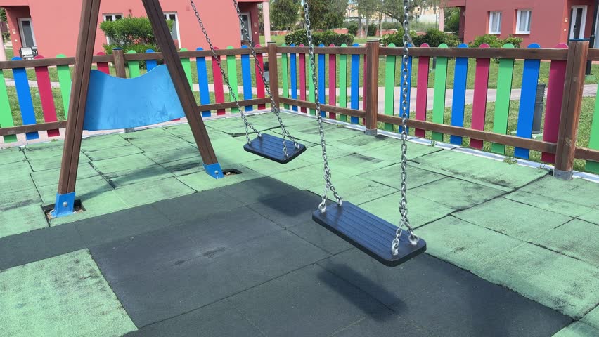 close up Double moved swing set on rubber safety flooring in outdoor playground