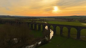 Scenic railway viaduct arching over peaceful countryside at sunset. Picturesque railway bridge captured in soft twilight. Expansive historic structure stretching across rolling green landscape under - Powered by Shutterstock - Get 15% off with code: PIKWIZARD15