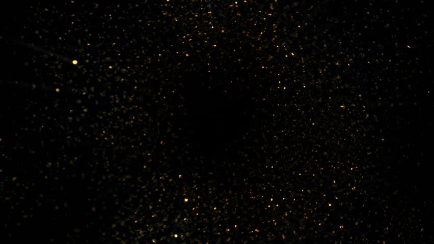 Super Slow Motion Shot of Rotating Golden Glitters Towards Camera Isolated on Black 1000fps.