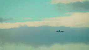 Passenger jet flying above dark cloud layer with blue sky above. Airliner moving through atmosphere in mixed weather conditions. Twin engine aircraft descending with stormy clouds in background - Powered by Shutterstock - Get 15% off with code: PIKWIZARD15