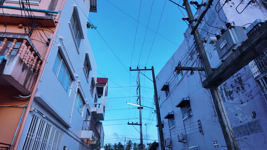 Urban alley twilight and dusk evening cityscape with apartment building facade, window and balcony railing, power line and utility pole, street light glow, calm serene mood, exterior architecture