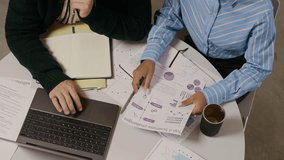 High angle shot of biracial woman and unrecognizable man looking at laptop screen, examining presentation and comparing it with report - Powered by Shutterstock - Get 15% off with code: PIKWIZARD15