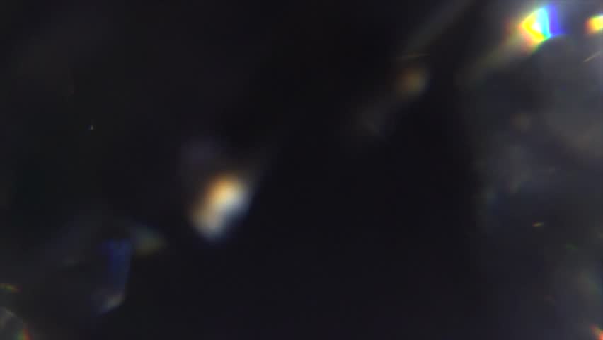 Lens Flare, abstract bokeh lights moving. Leaking Reflection of a Glass, Crystal, Defocused Shining Colorful rainbow Light Leaks, Rays on Black Background 