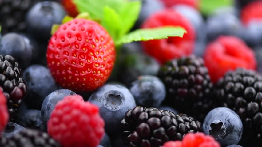 Fresh Berries. Various colorful berries rotating background. Mint leaves, Strawberry, Raspberry, Blackberry, Blueberry close-up, slow motion backdrop. Fresh Bio Fruits, Healthy eating, diet
