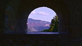 Carona, Switzerland – October 10, 2022: Lake Lugano and Monte Generoso seen through the stone archway of the Santi Giorgio e Andrea church. - Powered by Shutterstock - Get 15% off with code: PIKWIZARD15