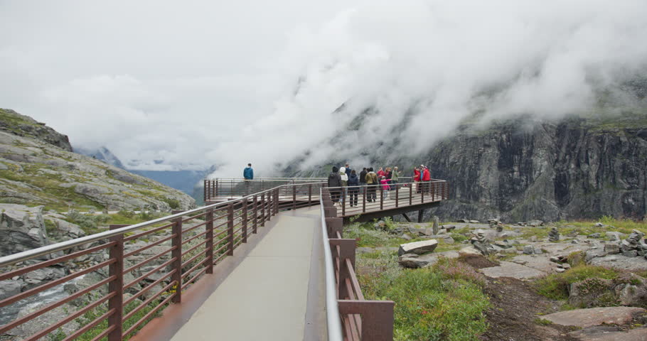 Trollstigen, NORWAY August 15, 2025: Trollstigen observation deck with tourists and fog over mountain cliffs, Norway