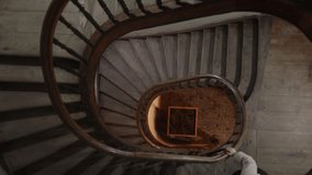 A woman walks up an old spiral staircase, her face unseen as warm ambient lighting highlights the elegant curves and vintage architecture. The scene captures quiet movement, atmospheric shadows and th - Powered by Shutterstock - Get 15% off with code: PIKWIZARD15