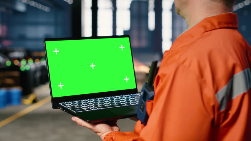 Mockup screen laptop with supervisor oversees construction and production tasks, surrounded by industrial machinery, metal tools and engineering elements that support strong manpower. Camera B.