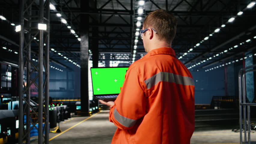 Mockup screen laptop with supervisor oversees construction and production tasks, surrounded by industrial machinery, metal tools and engineering elements that support strong manpower. Camera A.