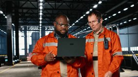 Diverse operators use laptop to coordinate production activity on the factory floor, highlighting manpower and the industrial environment for heavy manufacture and logistic tasks. Camera B. - Powered by Shutterstock - Get 15% off with code: PIKWIZARD15
