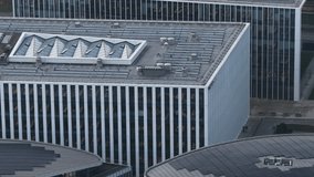 Detailed aerial view of a contemporary office building in Vilnius featuring rooftop skylights, solar panels, and ventilation systems, with visible interior workspaces. - Powered by Shutterstock - Get 15% off with code: PIKWIZARD15