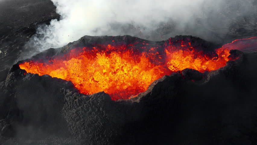 Volcanic eruption, red burning lava erupts from ground, drone fly over active volcano crater in Iceland