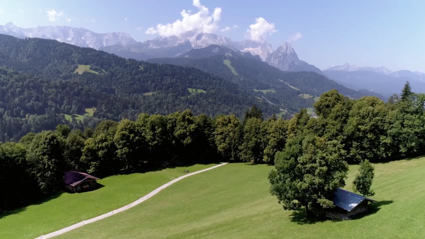 Scenic view of the Bavarian Alps with green meadow and path on a sunny summer day