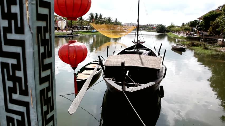 Traditional fishing boats and red lanterns adorn the river in Hoi An Vietnam