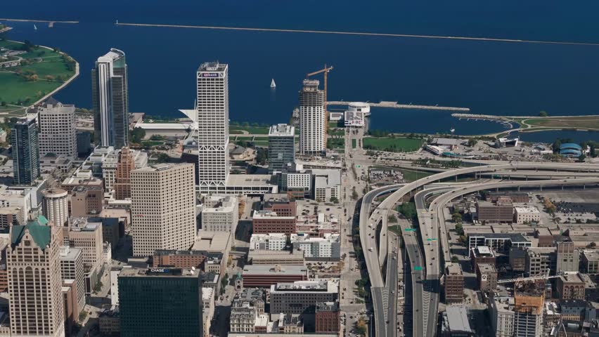 Aerial view of a downtown city and waterfront, capturing skyscrapers, urban streets, and riverside areas with expansive perspective and cityscape details.