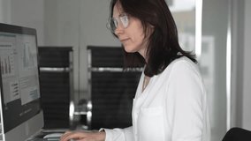 Businesswoman focusing on data analysis, working on computer in modern office, managing financial charts and reports, reflecting professionalism and corporate success. Business people concept - Powered by Shutterstock - Get 15% off with code: PIKWIZARD15