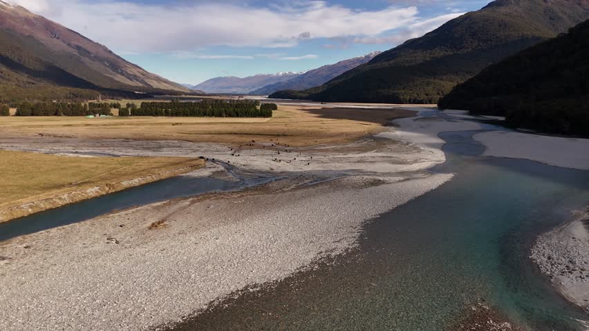 Drone flight through the Mount Aspiring valley and river with clear turquoise water.