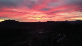 4K horizontal drone video of a vibrant Thanksgiving sunset near Burney Falls, California, showing a winding road, silhouettes of mountains, and dramatic pink and orange sky. - Powered by Shutterstock - Get 15% off with code: PIKWIZARD15