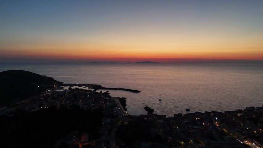 Sunset over Castelsardo in Sardinia, calm sea and colorful sky