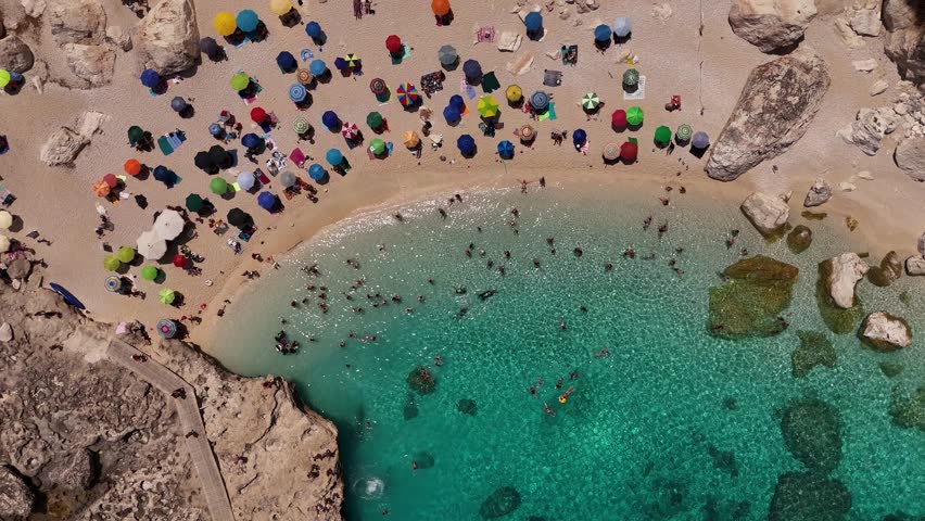 Aerial view of Cala Mariolu beach with umbrellas and clear waters in Sardinia