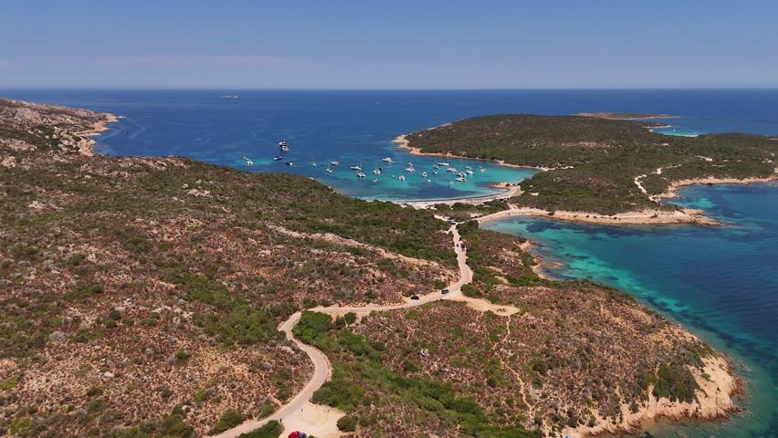 Yachts anchor in a serene lagoon under a sunny sky, aerial view