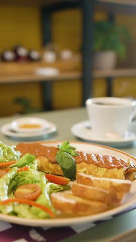 Steaming cup of coffee that blurs to reveal an omelet with salad and bread in a warm cafe atmosphere.