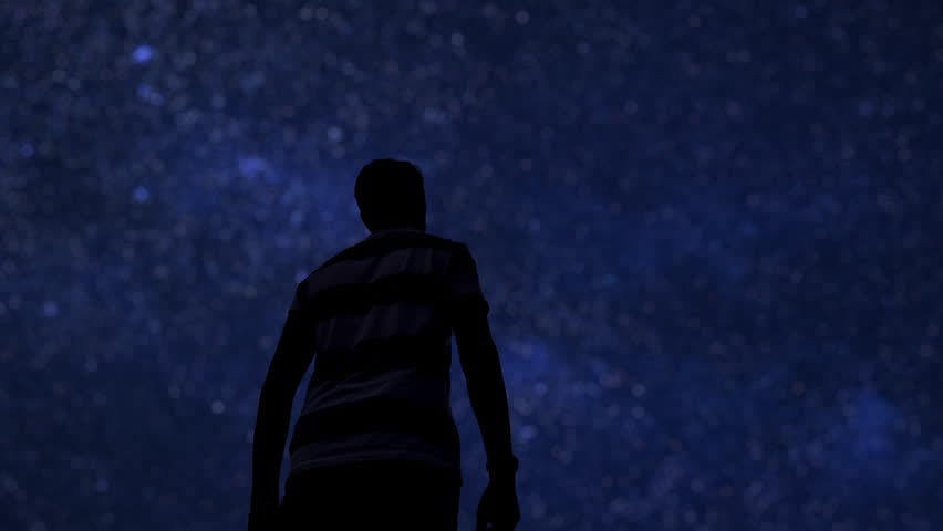 Silhouette of a man under the twinkling Milky Way stars.