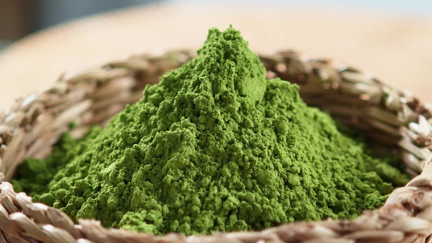 Premium matcha green tea powder in a wooden basket