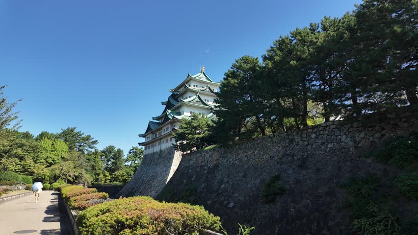Nagoya castle, Nagoya, Aichi, Japan, Traditional Japanese castle surrounded by trees and stone wall on clear day