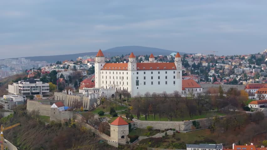 4K Aerial view of Bratislava Castle in Slovakia, capturing the grand courtyards, fortified walls, and panoramic cityscape stretching across the old town and modern districts. Slovakia_04