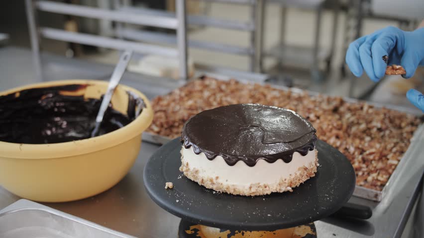 Baker Decorating Chocolate Walnut Cheesecake. Confectionery Production.