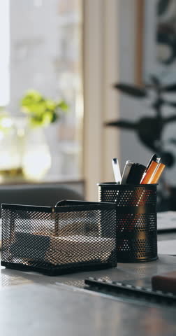 Business, notebook and stationery on desk in office for career, profession and creative tools. Empty, container and equipment with interior design, furniture and still life with wooden table