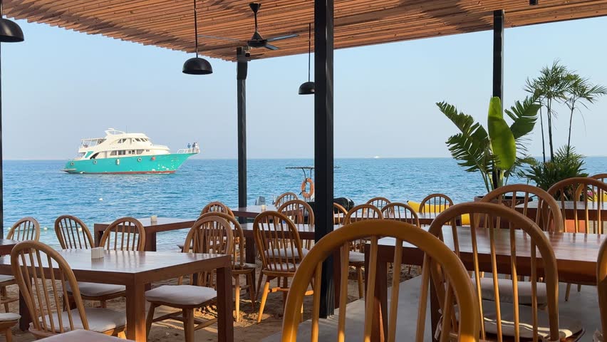 "Experience breathtaking oceanfront dining with stunning views of the turquoise sea and vibrant boats. Our open-air restaurant offers a serene escape with charming wooden furniture and tropical palms.