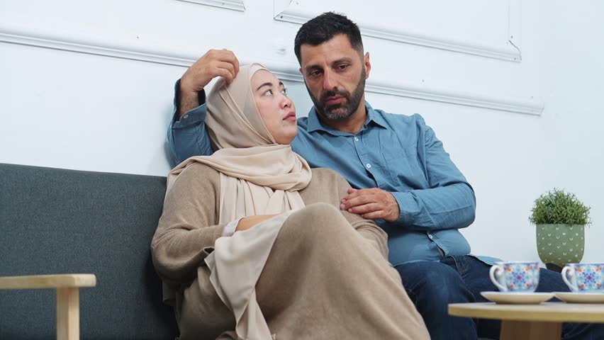 Intimate muslim couple sharing dreams while relaxing on sofa