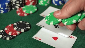 A player grips green poker chips while holding a winning hand of two aces on a casino table. Colorful chips stack nearby, creating an exciting atmosphere. - Powered by Shutterstock - Get 15% off with code: PIKWIZARD15