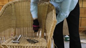 Gloved hands weave rattan chair in workshop. Rattan furniture made by hand. Eco friendly furniture concept. Craftsman deftly handles rattan stems. Workshop producing furniture from natural materials. - Powered by Shutterstock - Get 15% off with code: PIKWIZARD15