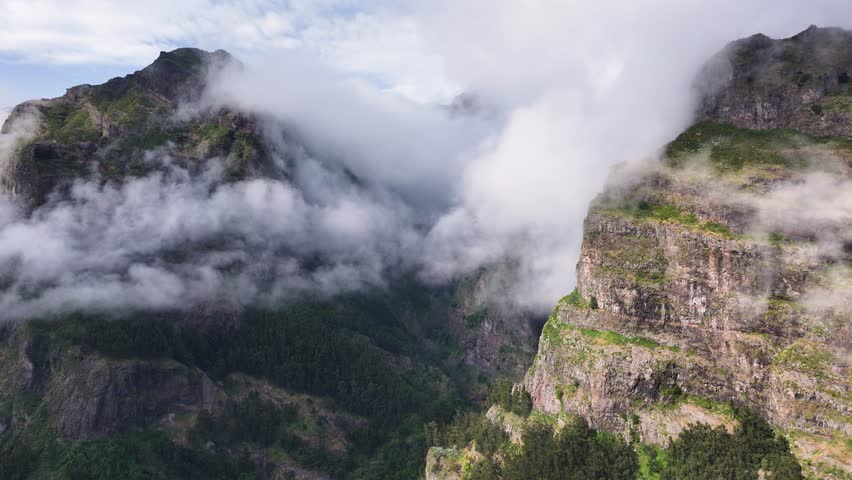 Eerie mountain fog cling to mountainsides at Curral das Freiras, Madeira. Aerial