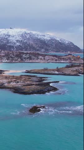 Experience the breathtaking beauty of Sommaroy islands in Troms, Norway during winter. Discover the serene beaches, icy waters, and snow-capped mountains and fishing village.