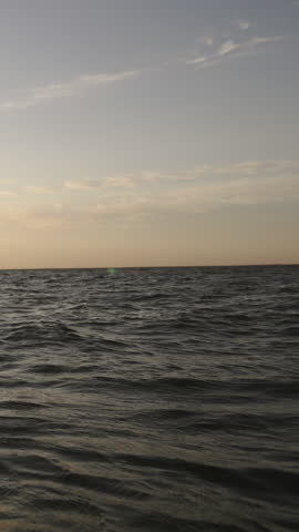 kitesurfer riding wave into sunset slow motion silhouette water splashes golden hour extreme sports adventure